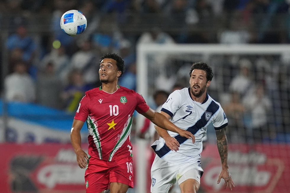 El surinamés Denzel Jubitana (izquierda) y el guatemalteco Aaron Herrera disputan el balón...