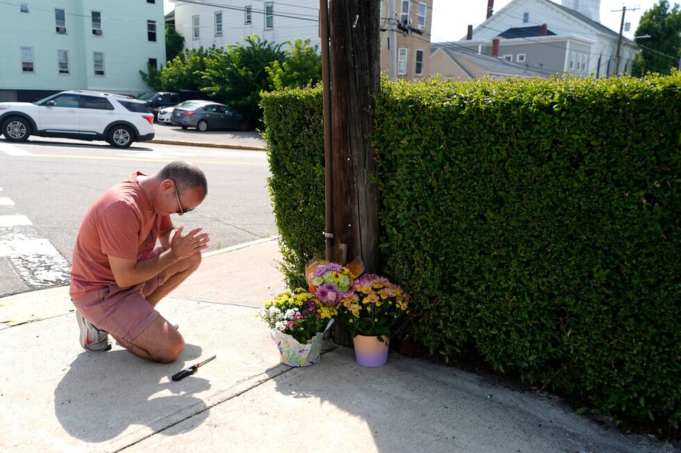 Misael Valdez se arrodilla cerca de unas flores colocadas en la intersección donde ocurrieron...