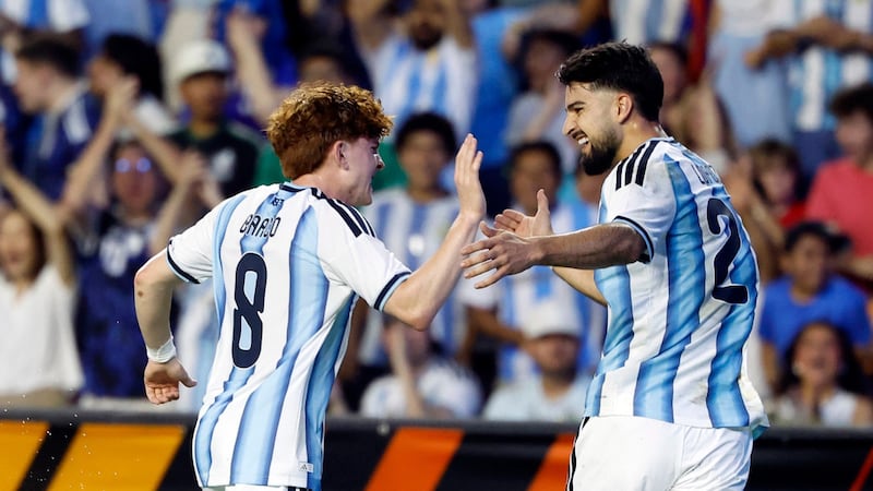 El mediocampista de Argentina, Valentín Barco (8), celebra con el delantero José López (21)...