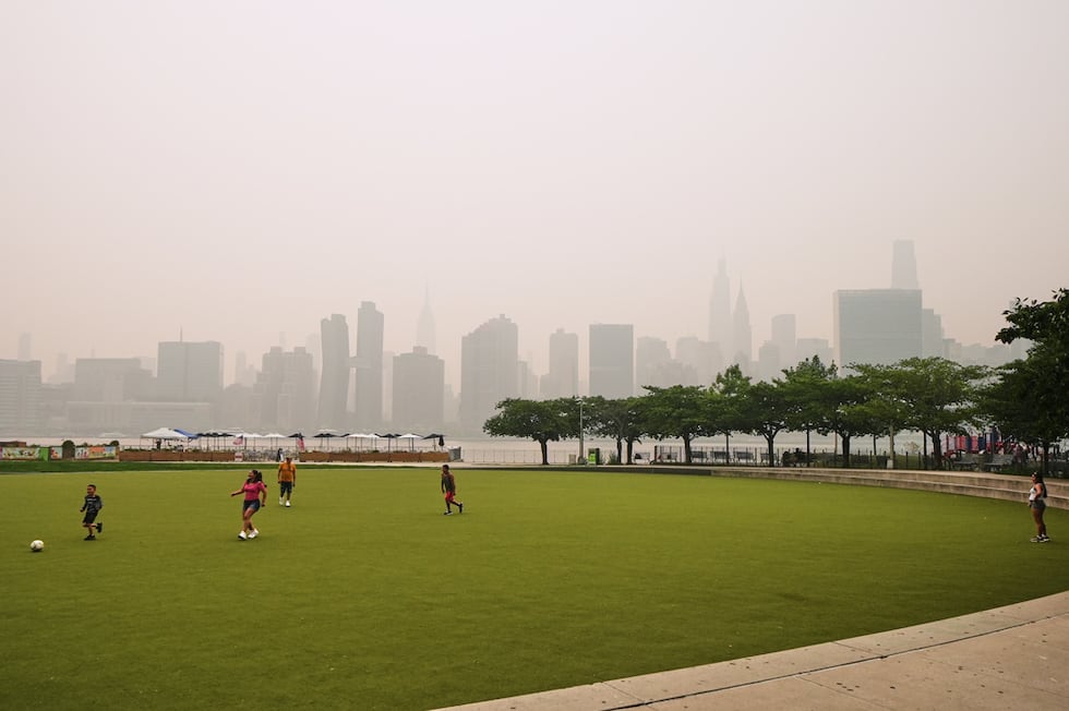 Un grupo de personas juega en el Hunter's Point South Park Athletic Field. Al fondo se...