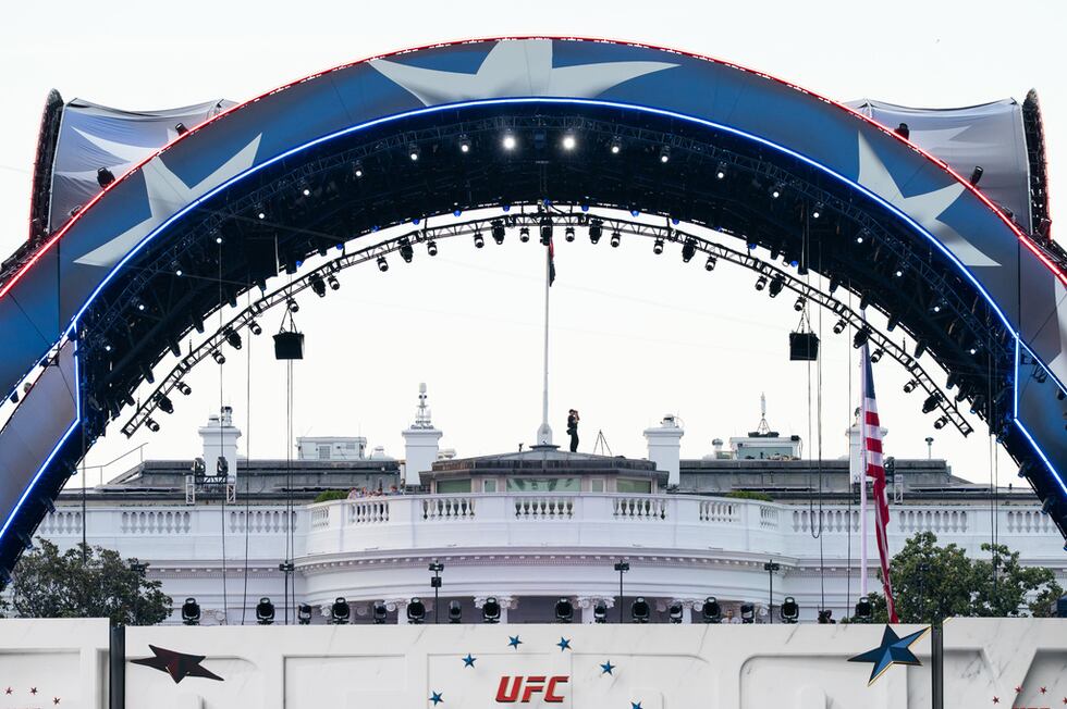 ARCHIVO - Un agente de seguridad en la Casa Blanca utiliza prismáticos durante el UFC Fan Fest...